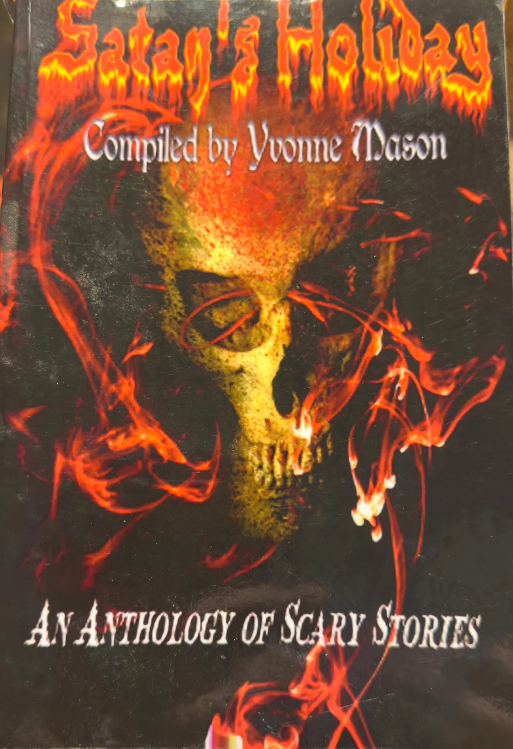 Cover of Satan’s Holiday: An Anthology of Scary Stories compiled by Yvonne Mason. A fiery skull glows against a black background surrounded by swirling red flames.