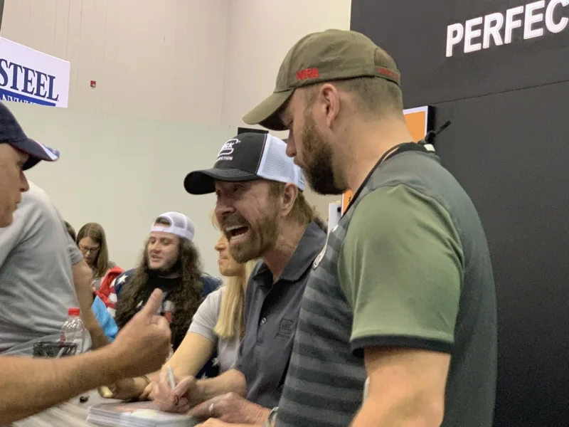 Chuck Norris signing autographs.